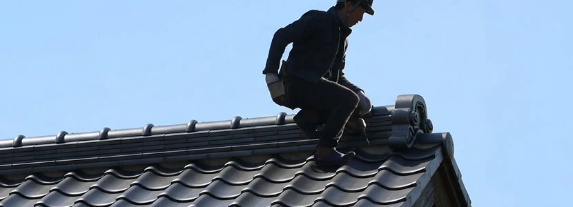 屋根の状態を確認する職人