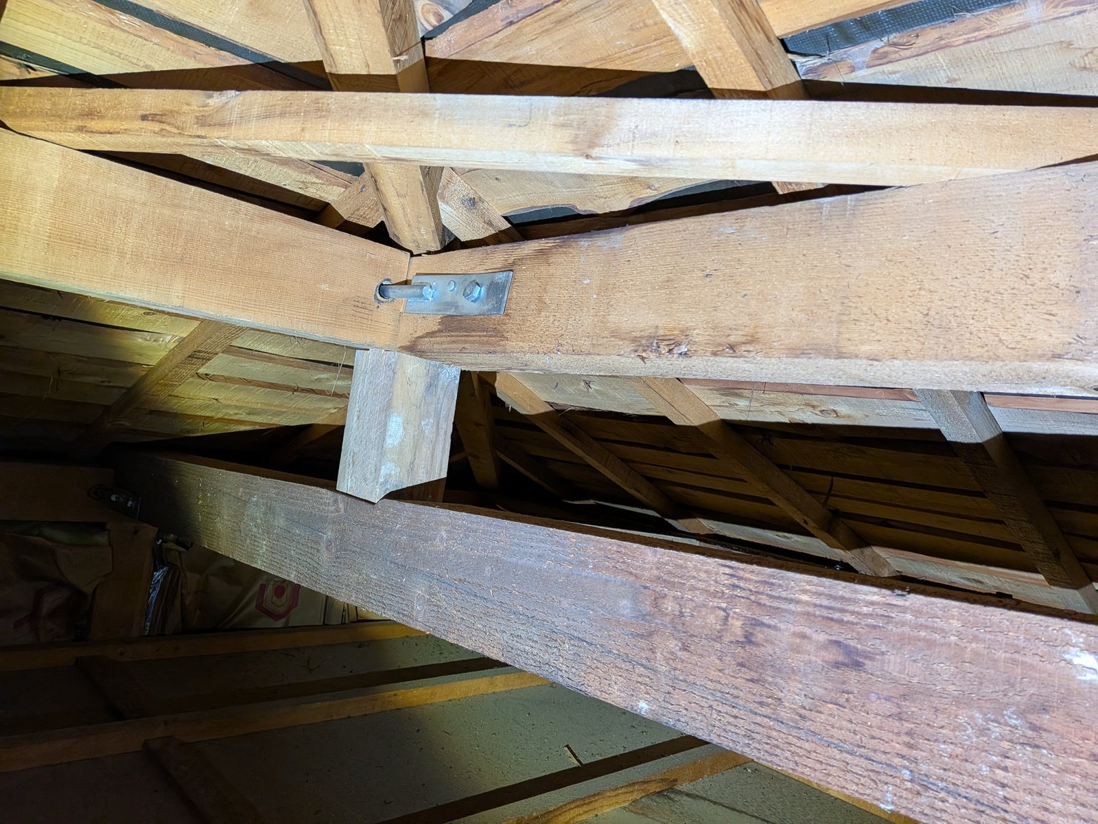 小屋裏（天井裏）の内部を撮影した実際の写真。垂木や母屋などの構造材が見え、雨漏りの形跡を確認できる場所。