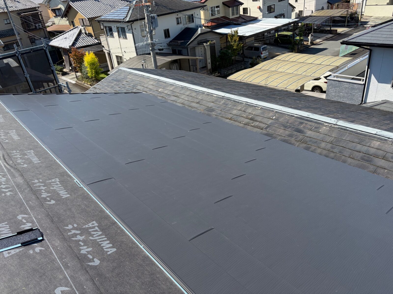 【施工中】北面もスーパーガルテクトを軒先から葺き上げ。ケラバ側の水切りに沿って納める